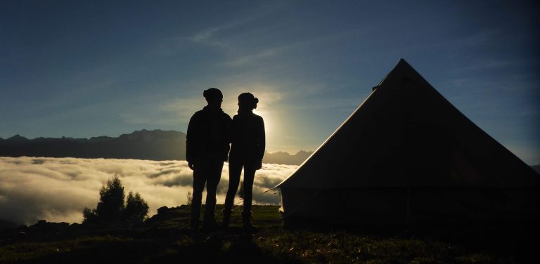 A couple enjoying the sunrise from their glamping tent in the Sacred Valley of the Incas